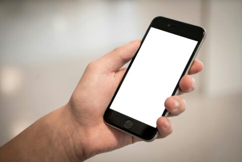 selective focus photography of person holding iphone displaying white screen